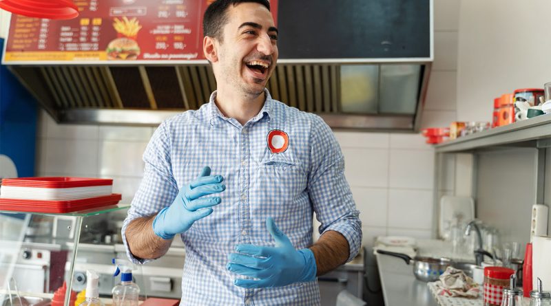 Image of a fast food worker smiling and looking happy to support minimum wage increase article